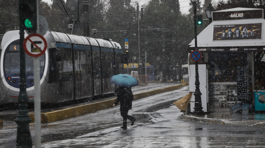 Άνδρας με ομπρέλα στο Σύνταγμα, ενώ βρίσκεται σε εξέλιξη η κακοκαιρία «Μήδεια»