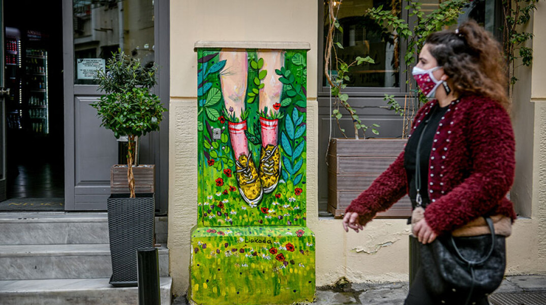 Αττική - Κορωνοϊός: Κοπέλα με μάσκα περνά μπροστά από κατάστημα στο κέντρο της Αθήνας, ενώ βρίσκεται σε ισχύ το σκληρό τοπικό lockdown