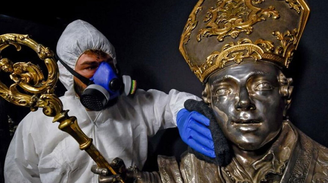 Κορωνοϊός στην Ιταλία: Μέλος συνεργείου με προστατευτική στολή καθαρίζει έκθεμα σε μουσείο στη Νάπολι