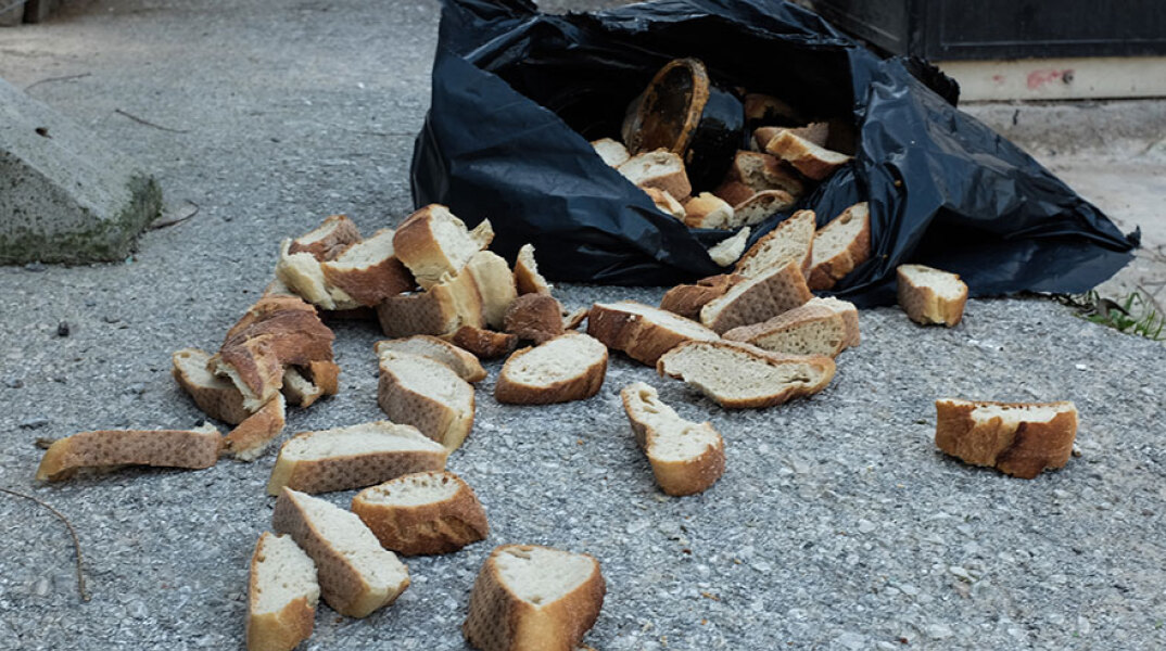 Ανοιγμένη σακούλα με φέτες ψωμί δίπλα από κάδο απορριμμάτων - Στην Ελλάδα φαγητό και τρόφιμα πετιούνται κάθε χρόνο χωρίς να καταναλωθούν