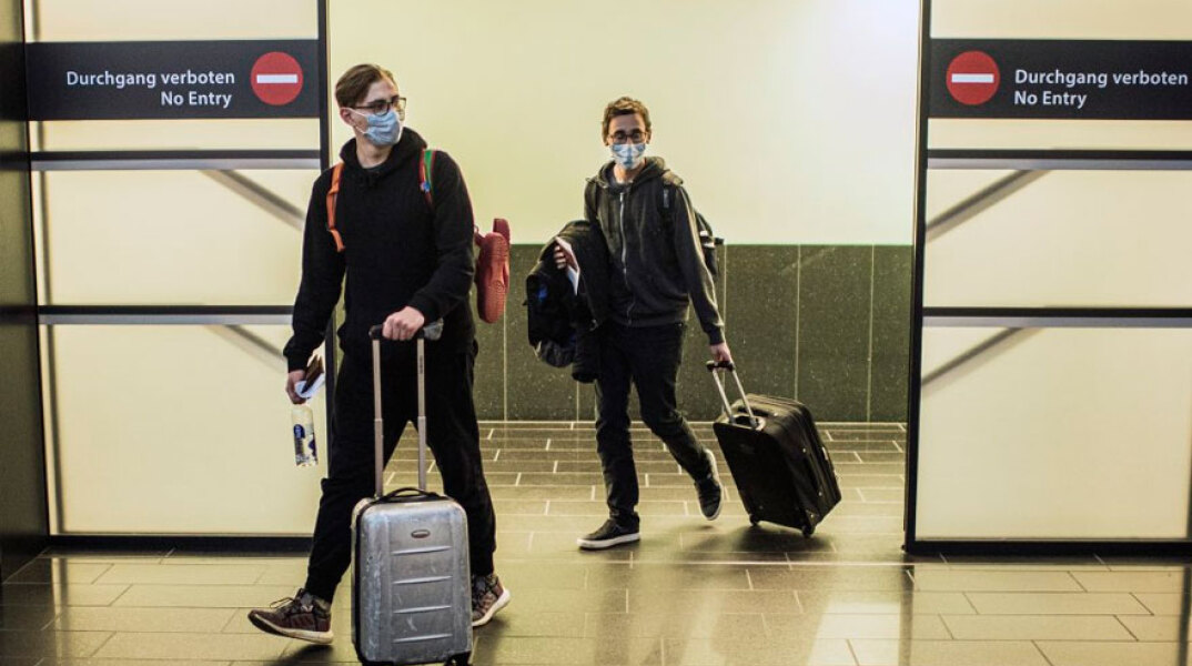 Αυστρία - Κορωνοϊός: Ταξιδιώτες με μάσκα στο διεθνές αεροδρόμιο στη Βιέννη