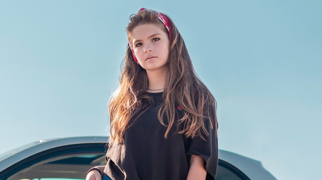 Κοπέλα στέκεται μπροστά από αμάξι