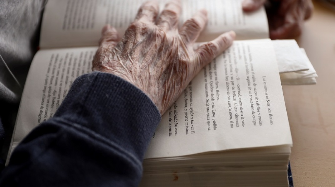 Ηλικιωμένος διαβάζει το βιβλίο του σε γηροκομείο