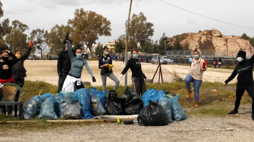 Οκτώ εθελοντές της ομάδας Save Your Hood με γεμάτες σακούλες σκουπιδιών