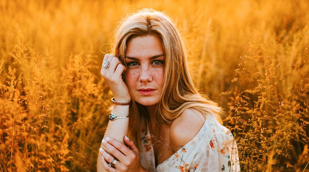 Κοπέλα με άσπρο φλοράλ φόρεμα σε χωράφι