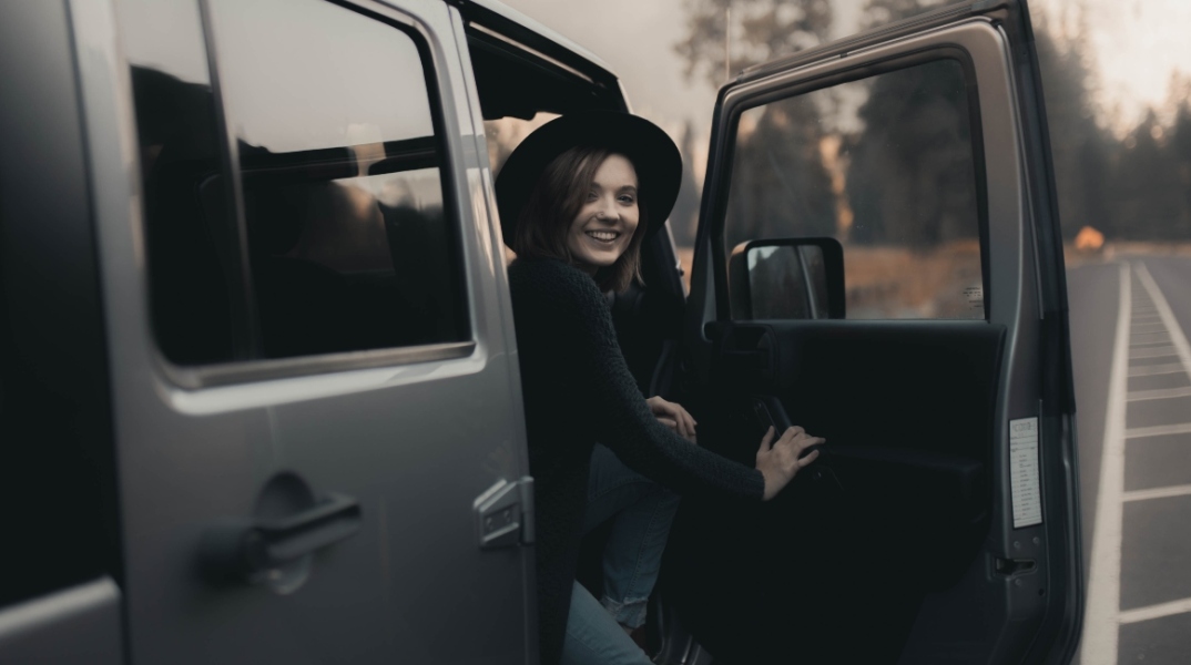 Κοπέλα με μαύρα ρούχα και καπέλο στο αυτοκίνητο