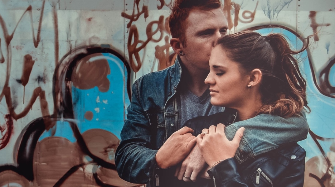 Άντρας αγκαλιάζει τη γυναίκα και τη φιλάει στο κεφάλι