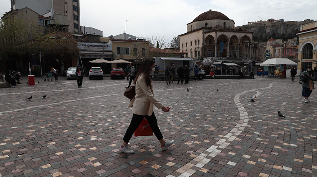 Αττική: Κοπέλα με μάσκα για τον κορωνοϊό περπατά στην κεντρική πλατεία στο Μοναστηράκι