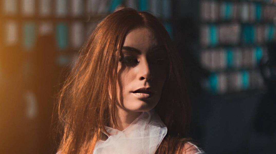 Γυναίκα φοράει λευκό διάφανο πουκάμισο