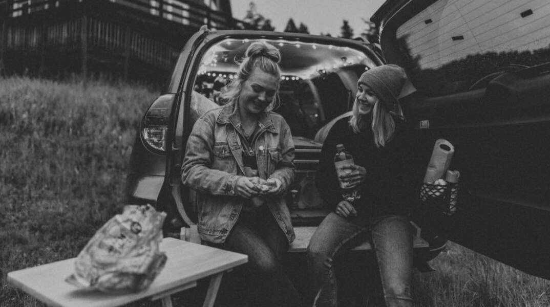 Ασπρόμαυρη φωτογραφία με δύο γυναίκες στο αυτοκίνητο