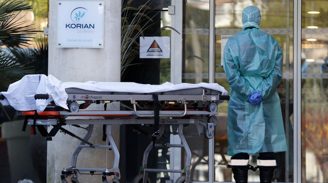 Κορωνοϊός στη Γαλλία: Νοσηλευτής με προστατευτική στολή έξω από νοσοκομείο