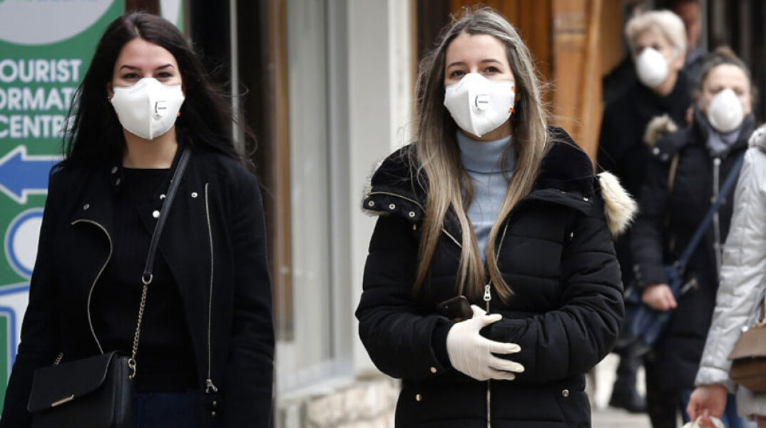 Βοσνία - Κορωνοϊός: Κοπέλες με μάσκα για τον κορωνοϊό περπατούν στο Σεράγεβο