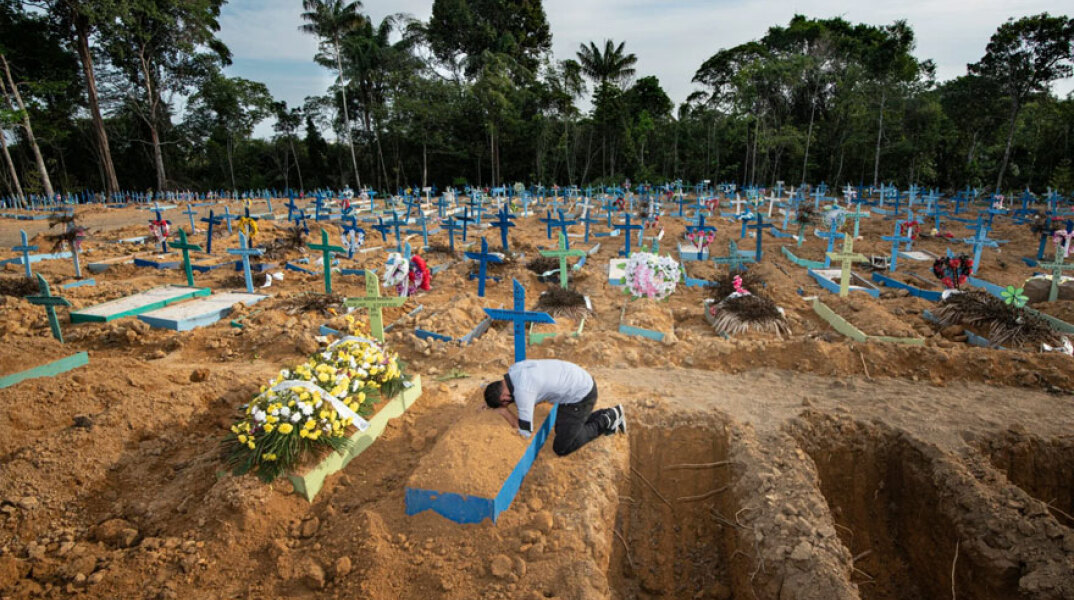 Βραζιλία - Κορωνοϊός: Ένας άνδρας θρηνεί στον τάφο της μητέρας του η οποία πέθανε από Covid-19 στην πόλη Μανάους, στον Αμαζόνιο