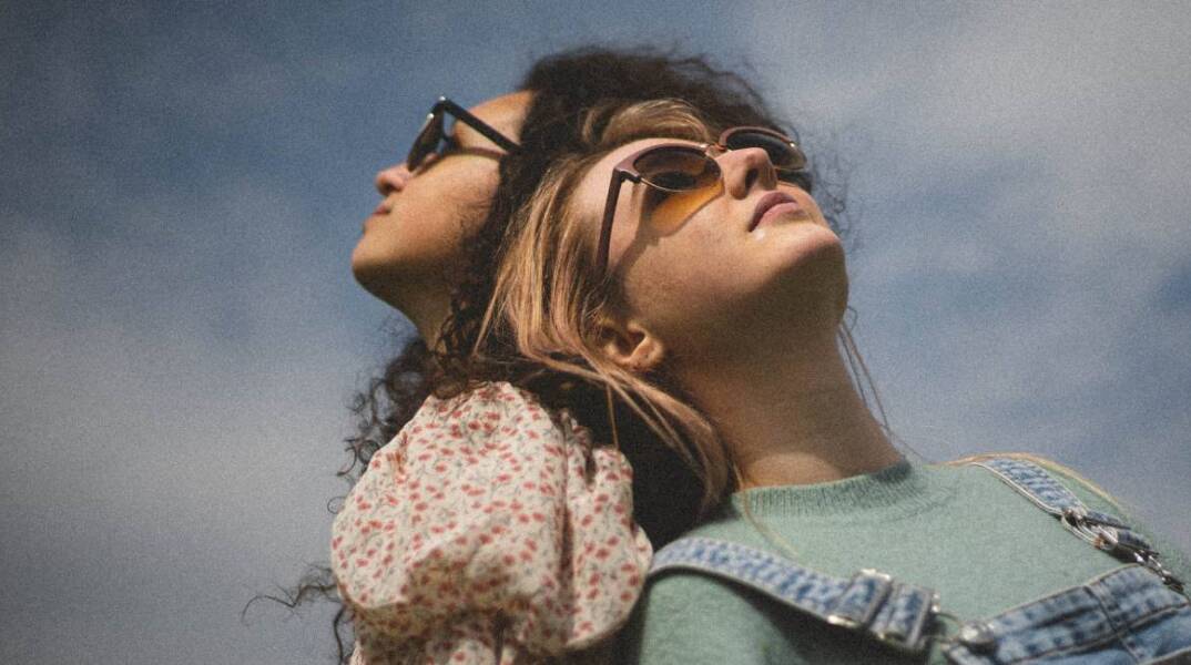 Δύο κορίτσια κάθονται στον ήλιο