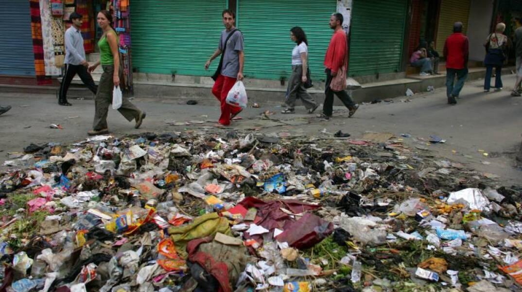 Κατμαντού - Τουρίστες περπατούν δίπλα σε τόνους σκουπιδιών στο Thamel