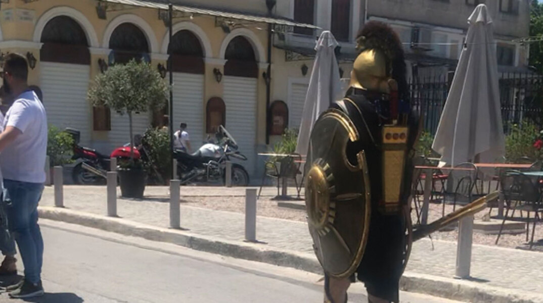 Άνδρας ντυμένος σπαρτιάτης πολεμιστής περπατάει στο δρόμο
