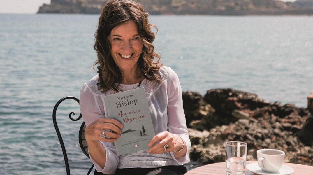 Η συγγραφέας Victoria Hislop κρατάει στα χέρια της το νέο της μυθιστόρημα «Μια νύχτα του Αυγούστου» (εκδ. Ψυχογιός)