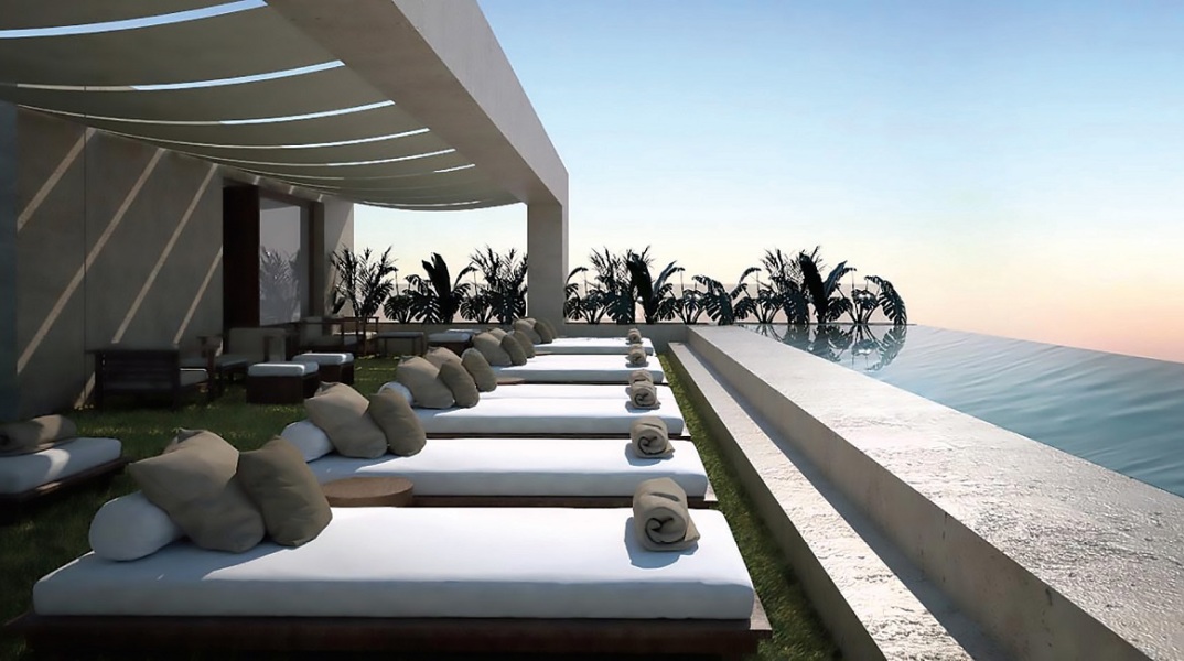 Ξαπλώστρες σε rooftop ξενοδείου με infinity πισίνα μπροστά τους