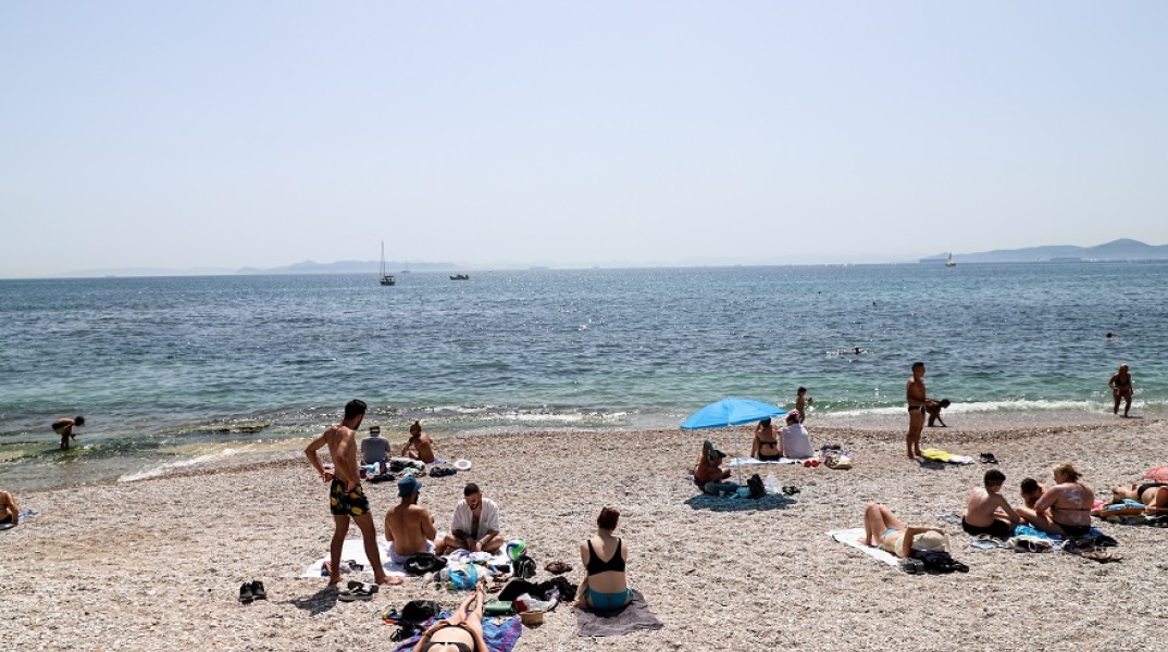 Πολίτες απολαμβάνουν το μπάνιο τους στη θάλασσα