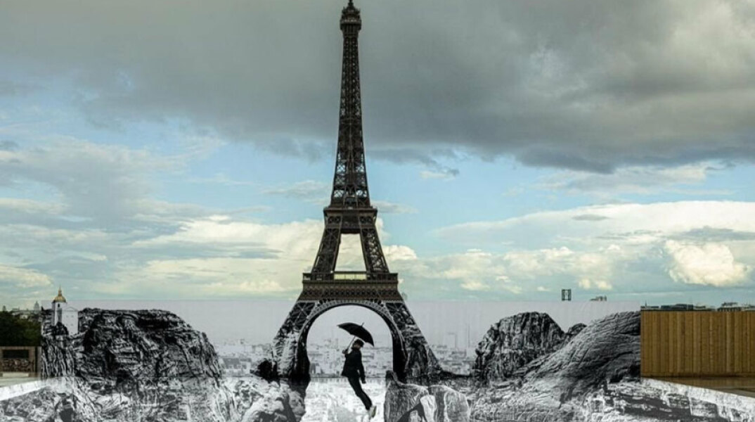 Άνθρωπος με ομπρέλα «πετά» πάνω από χαράδρα στο Παρίσι με φόντο τον Πύργο του Άιφελ