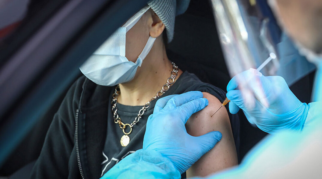 Εμβολιασμός για τον κορωνοϊό στην Πολωνία - Υγειονομικός χορηγεί το εμβόλιο σε πολίτη που βρίσκεται μέσα σε αυτοκίνητο