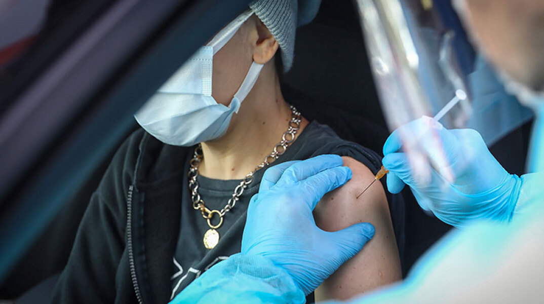 Εμβολιασμός για τον κορωνοϊό στην Πολωνία - Υγειονομικός χορηγεί το εμβόλιο σε πολίτη που βρίσκεται μέσα σε αυτοκίνητο