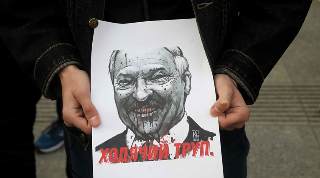 Διαδηλωτής στη Βαρσοβία (Πολωνία) κρατά σκίτσο του Αλεξάντερ Λουκασένκο, προέδρου στη Λευκορωσία, ζητώντας την απελευθέρωση του δημοσιογράφου Ρόμαν Προτάσεβιτς
