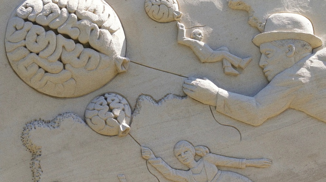 Γλυπτό στην άμμο που απεικονίζει ανθρώπους κι εγκεφάλους