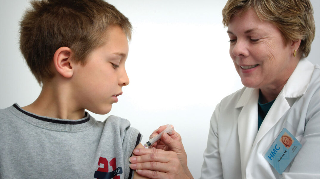Γυναίκα εμβολιάζει αγόρι