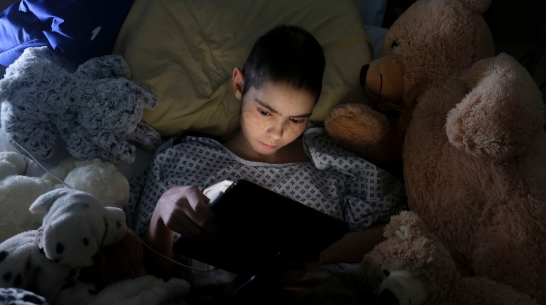 Η Rebecca Zammit Lupi, 15χρονη ασθενής με καρκίνο, παίζει ένα παιχνίδι στο iPad της tablet στο δωμάτιό της στην Πτέρυγα του Ουράνιου Τόξου στο Ογκολογικό Κέντρο Sir Anthony Mamo του νοσοκομείου Mater Dei, κατά τη διάρκεια της έξαρσης του κορωνοϊού, στην i