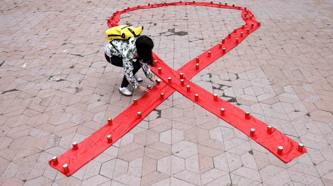 Ακτιβίστρια στη Σερβία σχηματίζει με κεριά την κορδέλα-σύμβολο για τον ιό HIV