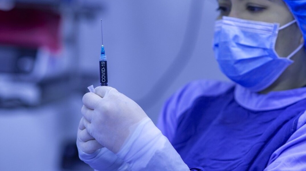 Γιατρός με μάσκα κρατάει στα χέρια της εμβόλιο κατά του Covid-19©Pixabay