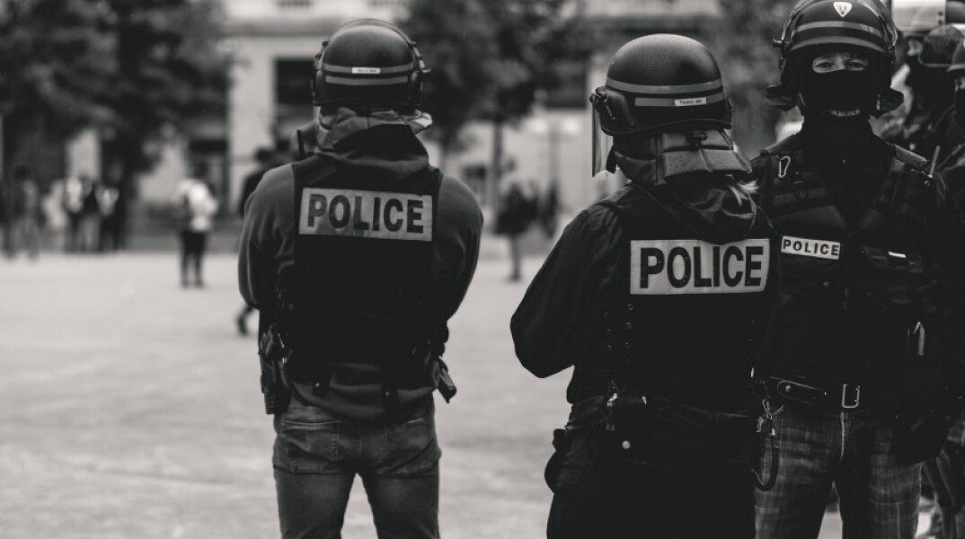 Αστυνομικοί, γυρισμένοι πλάτη, σε ασπρόμαυρη φωτογραφία©unsplash-ev