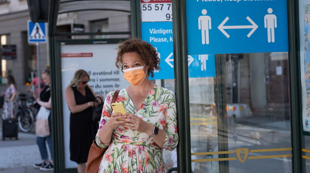 Σουηδία: Γυναίκα με μάσκα για τον κορωνοϊό σε στάση λεωφορείου