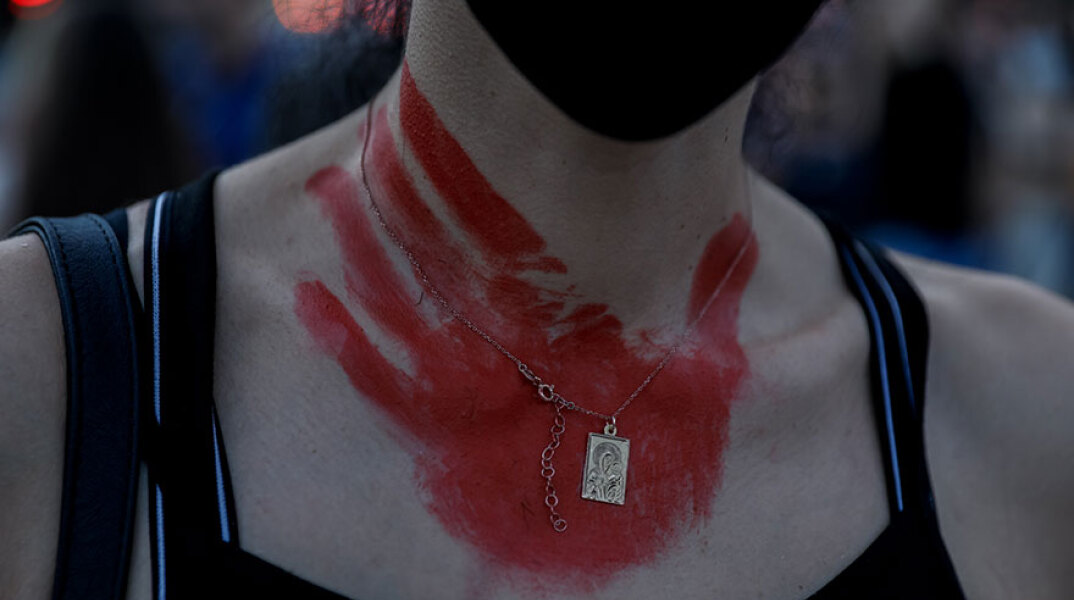 Κόκκινη παλάμη ζωγραφισμένη στο λαιμό γυναίκας που συμμετείχε στην παράσταση διαμαρτυρίας στο Σύνταγμα για τη δολοφονία της Καρολάιν