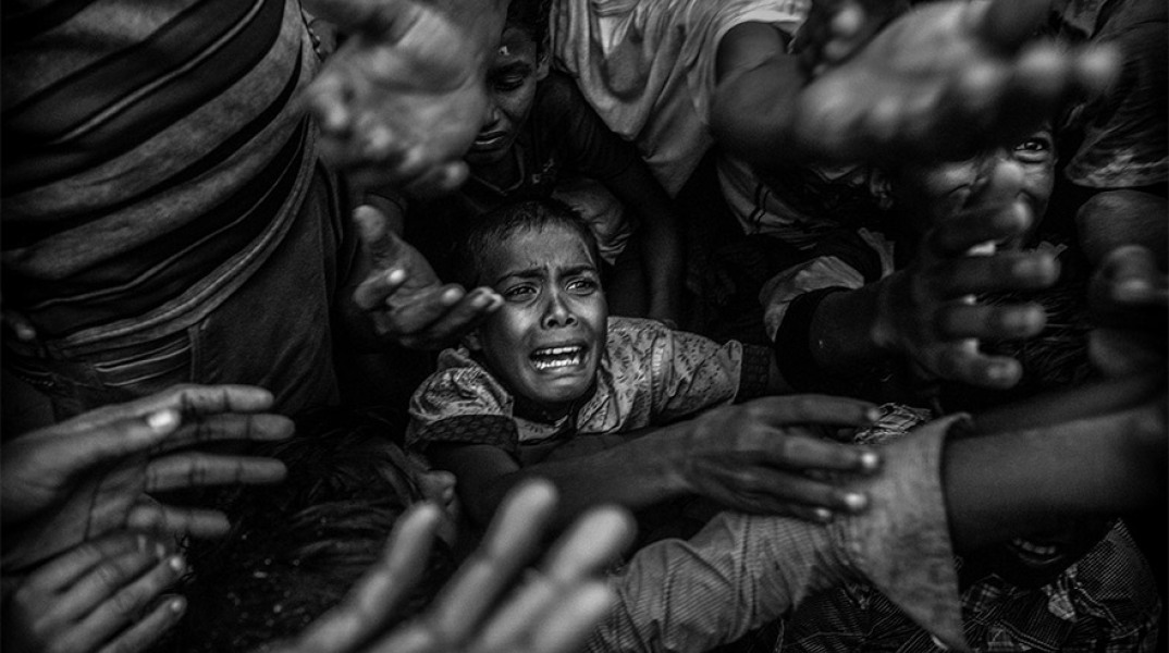 Ένα αγόρι προσφύγων Ροχίνγκια φωνάζει καθώς παλεύει στο πλήθος για να πάρει επισιτιστική βοήθεια από μια τοπική ΜΚΟ στο στρατόπεδο προσφύγων Balukali στις 18 Σεπτεμβρίου 2017 στο Cox's Bazar, στο Μπαγκλαντές
