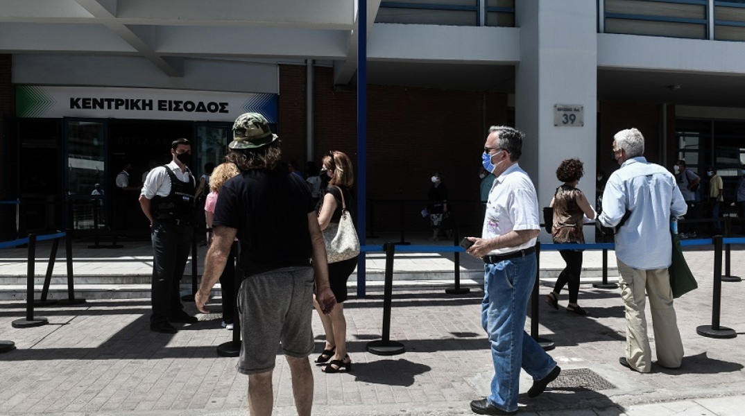 Πολίτες αναμένουν τη σειρά τους για εμβολιαστούν έξω από το εμβολιαστικό κέντρο