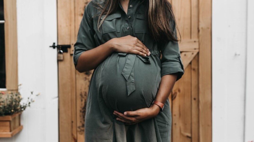 Μία έγκυος γυναίκα που κρατάει την κοιλιά της © Unsplash/Camylla Battani