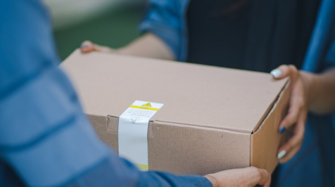Κούριερ παραδίδει δέμα © Unsplash/RoseBox