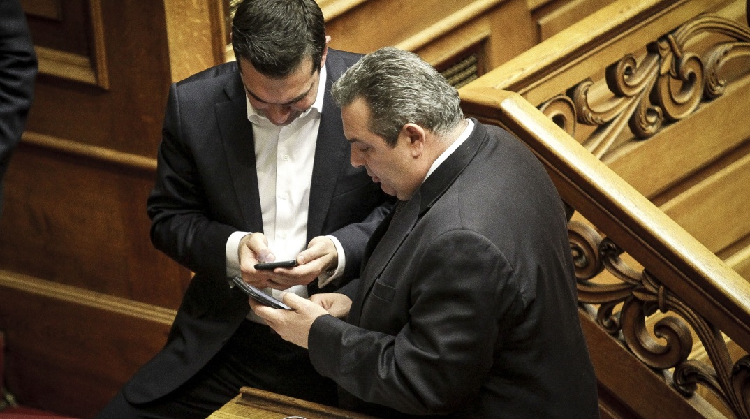 Αλέξης Τσίπρας και Πάνος Καμμένος κοιτάζουν τα κινητά τους τηλέφωνα στη Βουλή