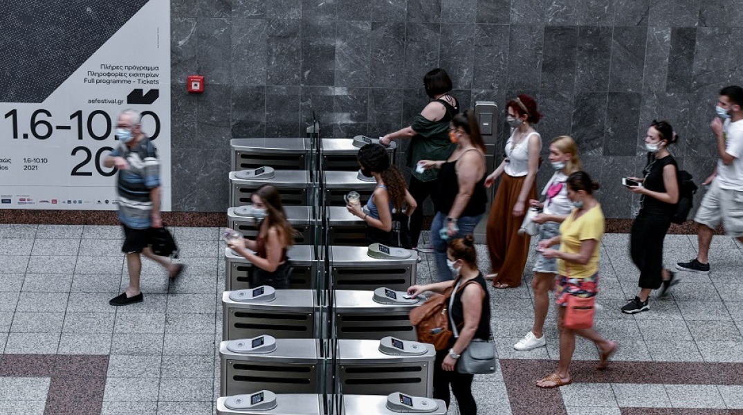 Επιβάτες του μετρό χτυπούν το εισιτήριο τους κατά την έξοδό τους από σταθμό