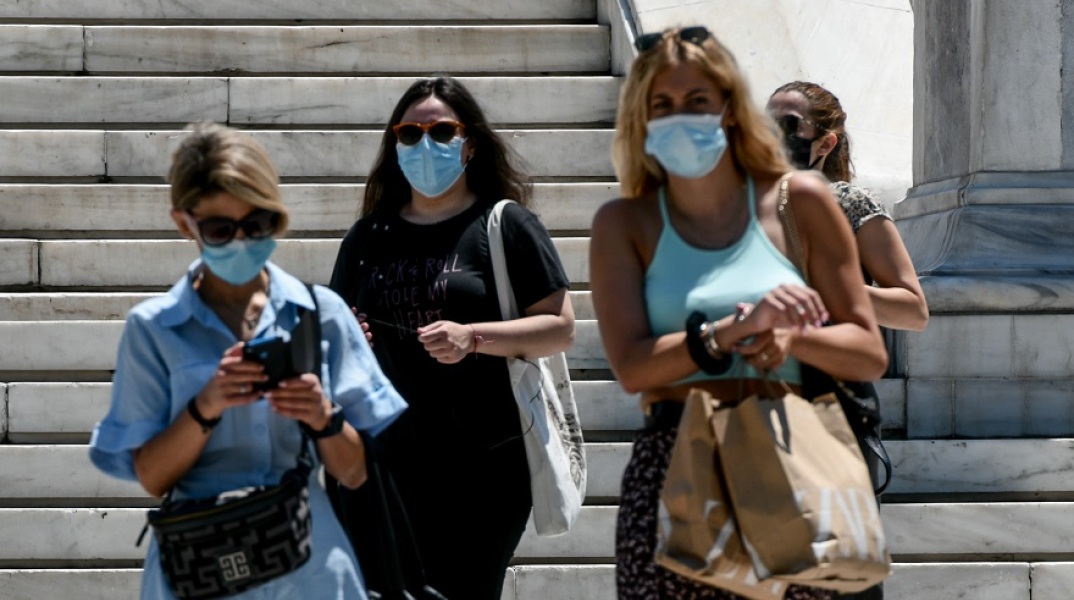 Κορωνοϊός: Γυναίκες φορούν τις μάσκες προστασίας και περπατούν στο κέντρο της Αθήνας