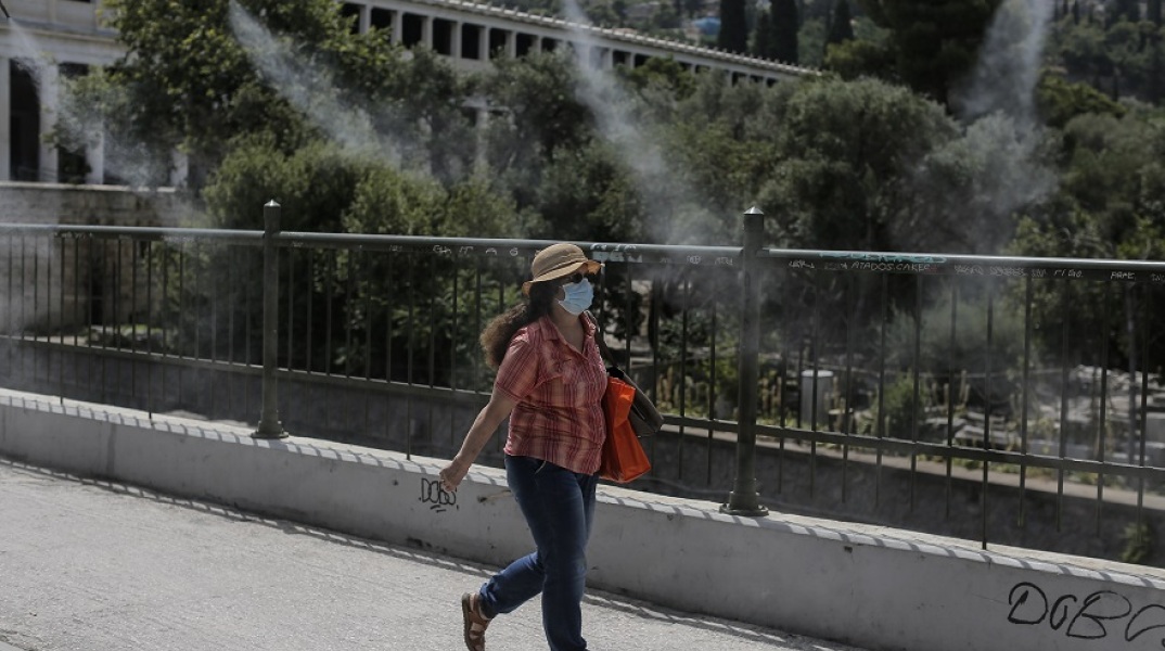 Κύμα καύσωνα - Γυναίκα με γυαλιά ηλίου και καπέλο στην Αθήνα