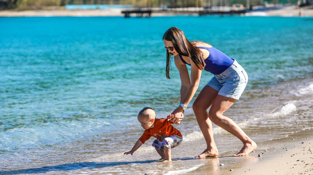 Γυναίκα με παιδάκι στην παραλία