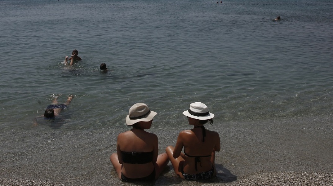 Καύσωνας: Λουόμενοι με καπέλα στην παραλία 