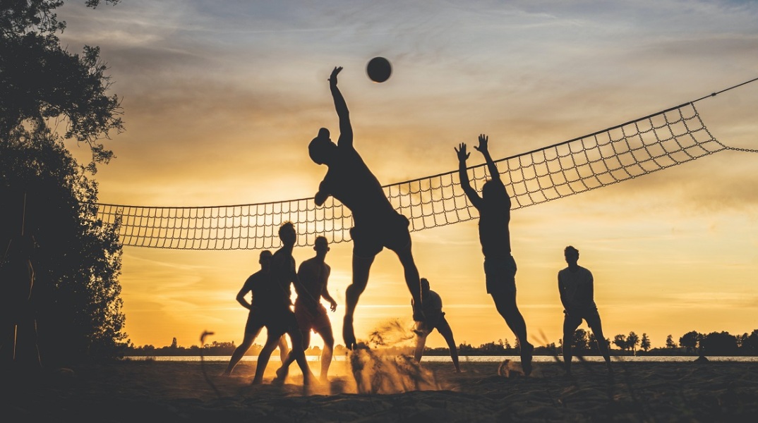 Μια παρέα παίζει βόλει στην παραλία. 