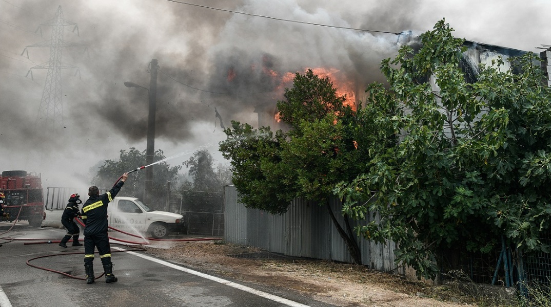 Πυροσβέστες επιχειρούν να σβήσουν τις φλόγες από σπίτι στις Αφίδνες.