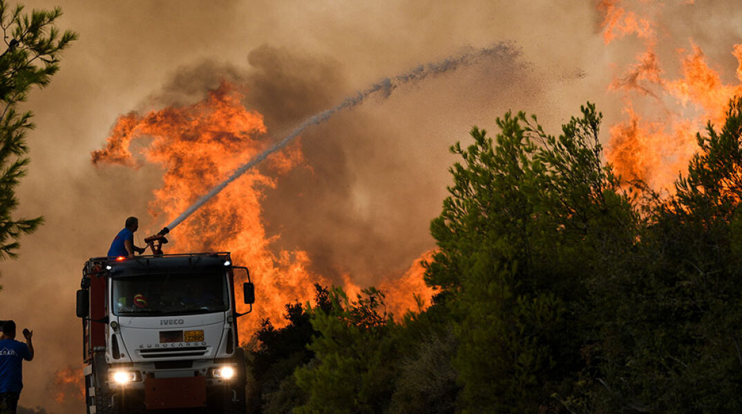 Φωτιά στην Αττική: Πυροσβεστικό όχημα ρίχνει νερό σε πυρκαγιά στη Σταμάτα