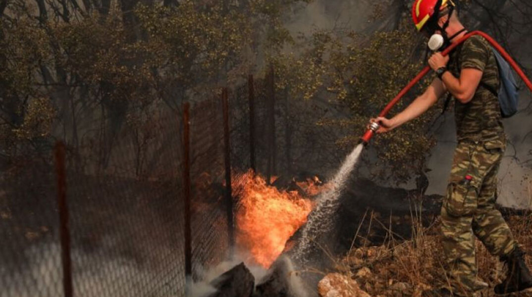 Πυροσβέστης ρίχνει νερό σε φωτιά (ΦΩΤΟ ΑΡΧΕΙΟΥ)