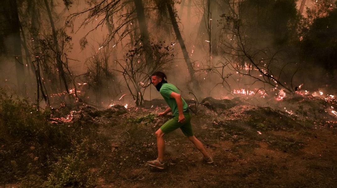 Στιγμιότυπο από την πυρκαγιά στο Πευκί - Νεαρός επιχειρεί στην κατάσβεση